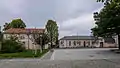 Zwei Schulgebäude (Alte Schule Nr. 8, Neue Schule Nr. 6 mit Zwischentrakt und angebauter Turnhalle) und von Hecken eingefasste Vorplatzgestaltung (1. Grundschule Coswig, Leonhard-Frank-Schule)
