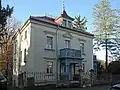 Villa mit massiv untersetzter Ecklaube und Einfriedung