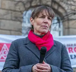 Eva Döhla hält Mikrofon in der Hand, guckt leicht rechts hinter Betrachter