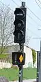 Signal, das eine Straßenkreuzung schützt: Es zeigt Halt (leuchtende horizontale Linie), aber das System hat die Annäherung eines Zuges erkannt (leuchtende gelbe Raute)