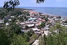 Blick auf Djoiezi. Flache Hausdächer im Grünen mit Blick aufs Meer.