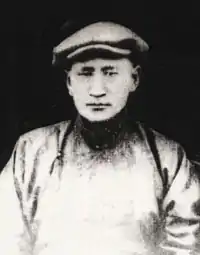 Dogsomyn Bodo. Schwarzweißfotografie eines Mannes in traditioneller mongolischer Kleidung mit flachem Filzhut.