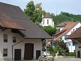Dorfplatz von Wölflinswil, im Hintergrund die klassizistische Pfarrkirche St. Mauritius (1821)