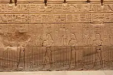 Relief mit vier Personen mit unterschiedlichen Hieroglyphen auf dem Kopf