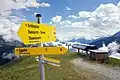 Wegweiser auf der Eggalm und die Bergstation der 6er Sesselbahn Lattenalm