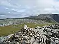 Der Gipfelcairn des Eididh nan Clach Geala, im Hintergrund der Meall nan Ceapraichean und der Beinn Dearg