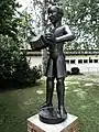 Emil Knöll (1889–1972), Skulptur, 1938, Handorgel spielender Knabe, Bruderholz Schulhaus, Basel