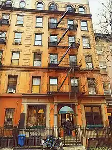 Ein Foto eines New Yorker Gebäudes mit 6 sichtbaren Stockwerken und einer Feuertreppe.