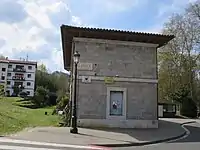 Ehemaliges Empfangsgebäude in Loyola: Links die ehemalige Bahntrasse, im Hintergrund ein Eisenbahntunnel