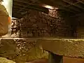 Fundamente der Fassade von St. Vitalis II; rechts ein Sarkophag