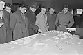 Eine Delegation des französischen Arbeitersportverbandes Fédération sportive et gymnique du travail (FSGT) vor einem Modell des DHfK-Komplexes (1954)