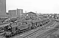 Personenzug mit Tenderlokomotive der Baureihe 242 TA der SNCF bei der Ausfahrt aus dem Bahnhof (1957)