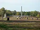 Friedhof auf dem historischen Lagergelände, mit Obelisk und Inschriftenwand, Jüdischem Mahnmal, Massengräbern und symbolischen Grabsteinen
