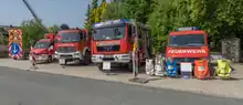 Das Foto zeigt den Fuhrpark der Feuerwehr. Von links nach rechts: Verkehrssicherungsanhänger, Gerätewagen Logistik, Löschgruppenfahrzeug für Katastrophenschutz, Hilfeleistungslöschgruppenfahrzeug