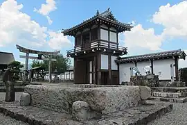 Tor, davor die steinerne Brunnenfassung