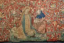 Geburt Christi nach der Vision der Birgitta von Schweden. Szene aus dem Marienteppich, Mittelrhein um 1500/1510, Domschatz Halberstadt. Das Christuskind im Strahlenkranz auf dem Boden, daneben die kniende Maria und Joseph mit einer Laterne. Im Hintergrund Ochs und Esel. Vorne Hund, Einhorn und Kaninchen.