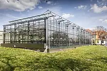 Im Vordergrund ist ein Gewächshaus von der Firma Strube in Schlanstedt zu sehen. Im Hintergrund befindet sich eines der Labor- und Büro-Gebäude.