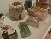 Fundstücke der Ausgrabungen, wie Fragment eines Glashafens, Tonmodeln für Flaschen und Glasmasse
