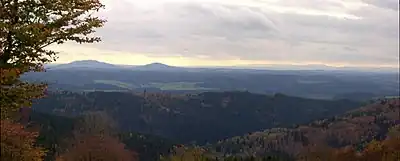 Blick vom Simmersberg (781 m) im Thüringer Schiefergebirge auf die 24 km entfernten Gleichberge. Rechts im Hintergrund die Hohe Rhön mit dem 67 km entfernten Kreuzberg (927,8 m), unmittelbar davor (halbrechts mittig) der 7 km entfernte Ratscher Bergsee