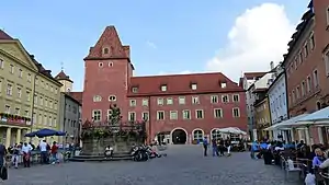 Blick von Osten über den Haidplatz (2017) und Blick von Westen über den Haidplatz (2014) auf die Arch (links), Goldenes Kreuz (rechts) und auf Neue Waag und Thon-Dittmer-Palais (links) In der Platzmitte der Justistiabrunnen