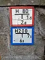 Rotes und blaues Hydrantenschild übereinander. Der blau gekennzeichnete Hydrant ist nicht für die Entnahme von Löschwasser vorgesehen und kann z. B. für Trinkwasser auf einem Markt genutzt werden.