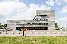Gebäude, bestehend aus zwei Rechtecken und einer Glasfront in der ersten Etage.