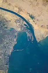 Satellitenansicht des Hafens, der Stadt und des südlichen Endpunktes des Suezkanals, der durch Ägypten verläuft und in der Nähe von Port Said ins Mittelmeer mündet.  (Oben ist Nordost).