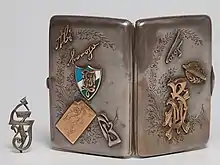 Zigarettenetui mit Zirkel der Basler Verbindung Jordania,[4] in der Sammlung des Jüdischen Museums der Schweiz.