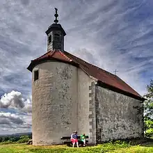Gangolfskapelle (1597). Saalbau mit zweitem Geschoss als Glockenstube, halbrunde Apsis.