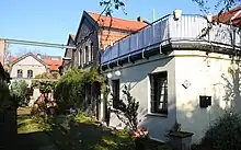 Hinterhof mit ehemaligen Gewerbebauten aus Backstein. Im gepfalsterten Boden sind Reste von Gleise erkennbar. Über dem Hof quer zwei Stahlträger mit Resten einer Krananlage