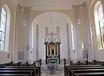 Blick in den Chorraum mit modernem Altar, Taufstein und neuer Kanzel