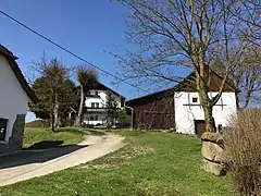 Von l. n. r.: Nr. 14 Lehrerhaus. Holzkreuz anstelle Kirchturm. Nr. 15 Mesnerhaus. Totenhäusl, Gruft der Herrschaft Clam
