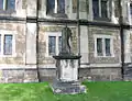 unleserliches klassizistisches Grabmal hinter der Kirche