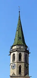 Turm der Evangelischen Stadtkirche Schorndorf, 66 Meter Höhe mit langgezogenem, achteckigem Pyramidendach, gedeckt durch grün lasierte Ziegel, welches in einer Turmkugel, einem Metallkreuz und einem Wetterhahn seinen Abschluss findet.