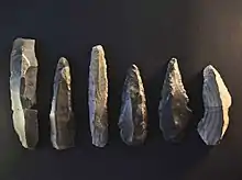 Klingengrundform (Fragment) links (Länge: noch 14,5 cm) und Klingengerätschaften aus Rijckholtfeuerstein (Fundort: Duisburg-Serm)