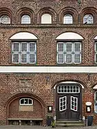 Südgiebel mit barocker Eingangstür, Sitznische und Wappentafel