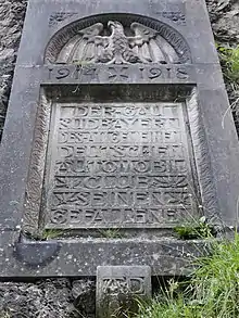 Kriegerdenkmal des ADAC in der Felswand oberhalb der Straße.