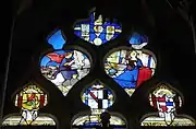 Maßwerk mit der Verkündigung des Herrn, darüber der Kopf des heiligen Claudius, und darunter die Wappen der Stifterfamilie