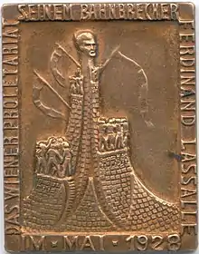 Dieser Anstecker aus dem Jahr 1928 zeigt das Lassalle-Denkmal im Winarsky-Hof in der Brigittenau (Wien), das 1936 abgetragen wurde