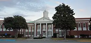 Liberty County Courthouse (2014). Das Courthouse entstand 1926 im Stile des Neoklassizismus und geht auf den Architekten J. J. Baldwin zurück. Im Jahr 1965 wurden zwei Gebäudeflügel angebaut. Im September 1980 wurde das Liberty County Courthouse als fünftes Objekt im County in das NRHP eingetragen.