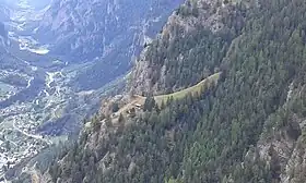 Blick von Wintergadmen in 1809 m ü. M. auf das Maiensäss Teli in 1611 m ü. M. Sichtbar sind das Teli-Kreuz, das Wohnhaus und die Stallung direkt oberhalb.