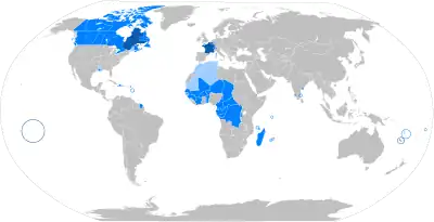 Grafische Weltkarte mit farbig markierten Ländern, in denen Französisch gesprochen wird. Kleine Regionen und Inseln sind eingekreist.