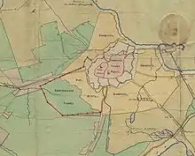 Farbfotografie einer alten, geknickten Karte mit farbig markierten Stadtteilen, Grünflächen und Wasserwegen. Die Beschriftung ist in kyrillischer Schrift.
