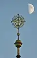 Die Turmspitze bildet ein Marienmonogramm als Wetterfahne