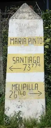 Steinerner Wegweiser im Zentrum von María Pinto