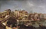 Ölgemälde eines Flussufers mit Handelsbooten und Menschen, die Waren ausladen. Links führt eine überbaute Bogenbrücke zum anderen Ufer, an der eine lange Häuserreihe mit schlichter Fassade und Schornsteinen bis rechts geht.