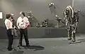 Markus Meurer (mit Besucherin) vor seinen Werken (2014) in der Halle Saint-Pierre (Paris)