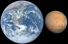 Die blau-weiße Erde und der braune Mond sind direkt nebeneinander abgebildet. Schwarzer Hintergrund.