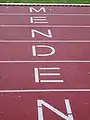„Menden“-Schriftzug auf der Laufbahn des Huckenohlstadions