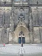 Westportal, Pflastermosaik, rote Vermessungsmarke am Sockel des Nordturms